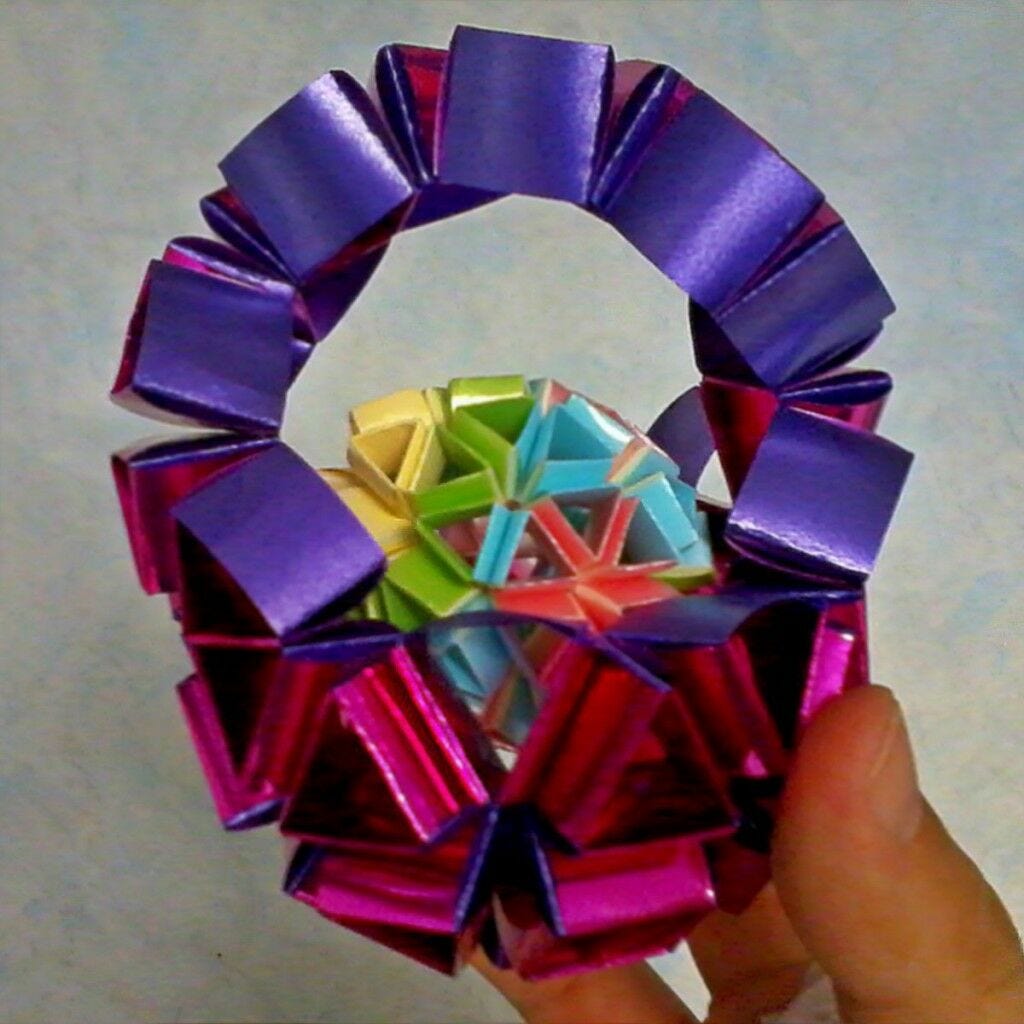 Snapology Basket hand holding small purple and pink colorful gift wrap basket with snapology ball