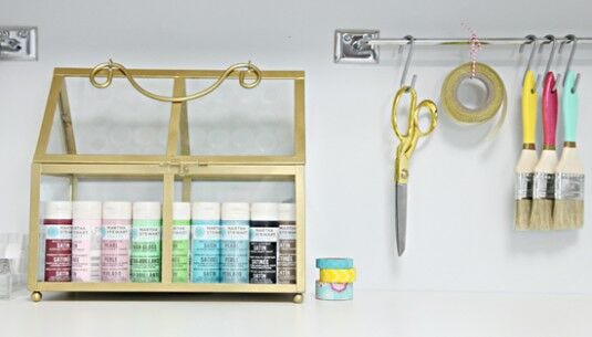 paint, brushes, ribbon, scissors paint on shelf, scissors, ribbon, paint brushes