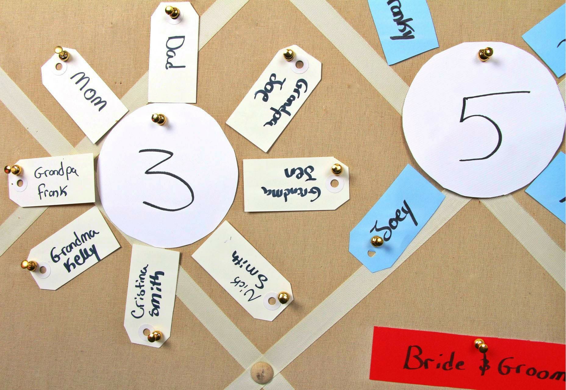 how to make a wedding seating chart with paper, push pins, and gift tags