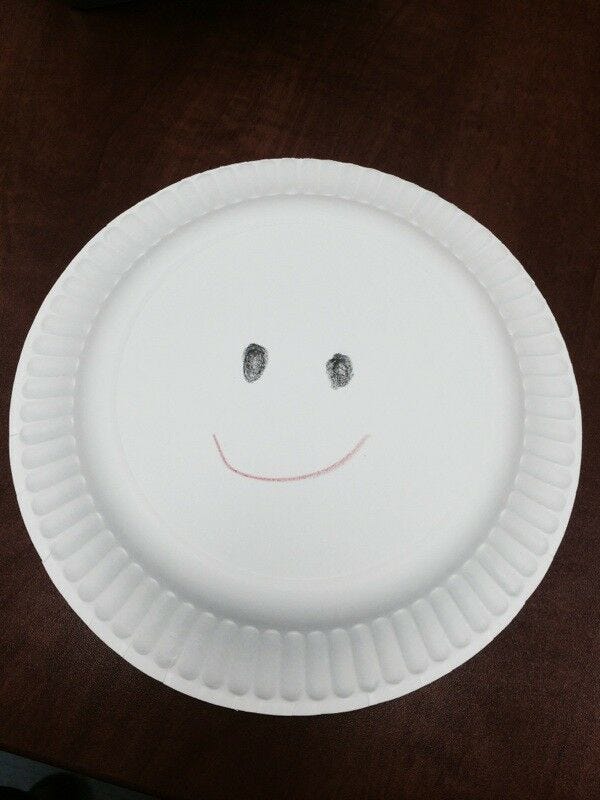 white paper plate with smiley face drawn on