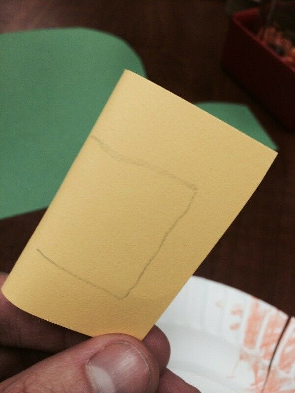 yellow paper cut into buckle shape along pencil lines