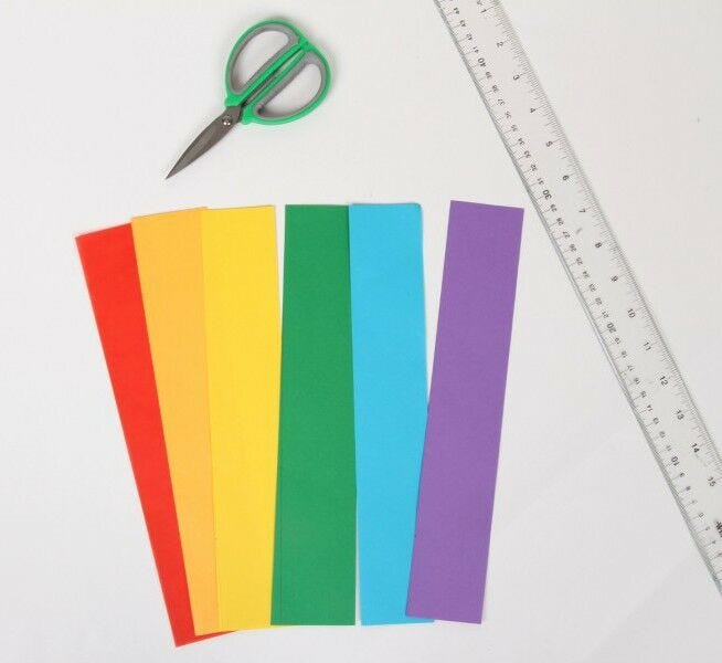 rectangle strips of rainbow multicolored paper with scissors and clear ruler