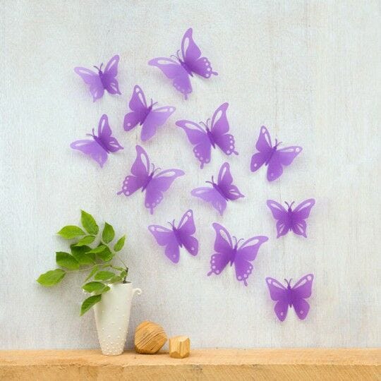 purple butterflies with plant in vase against gray and white wall