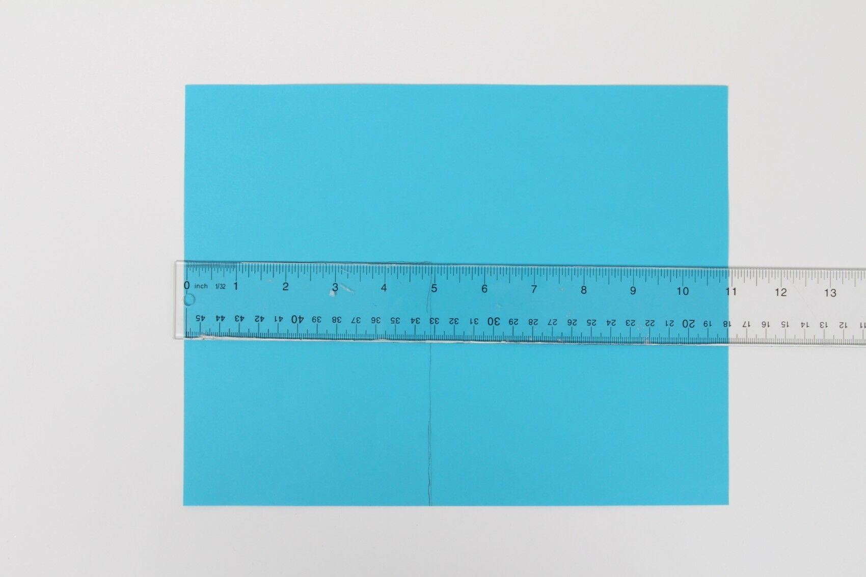 Blue envelope seal with clear ruler across it taking measurements