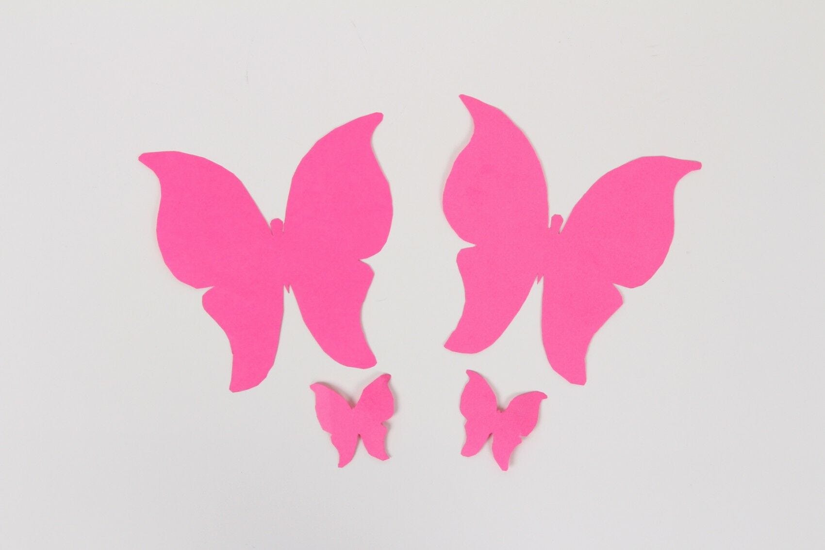 pink butterfly cutouts on white wall