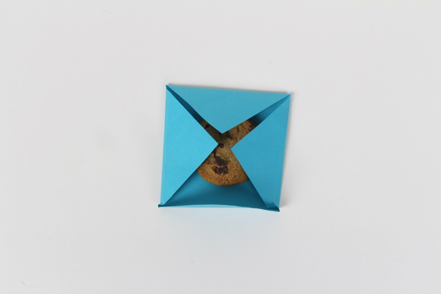 Chocolate chip cookie folded in blue envelope seal