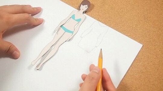 pencil tracing of female paper doll dress on white paper