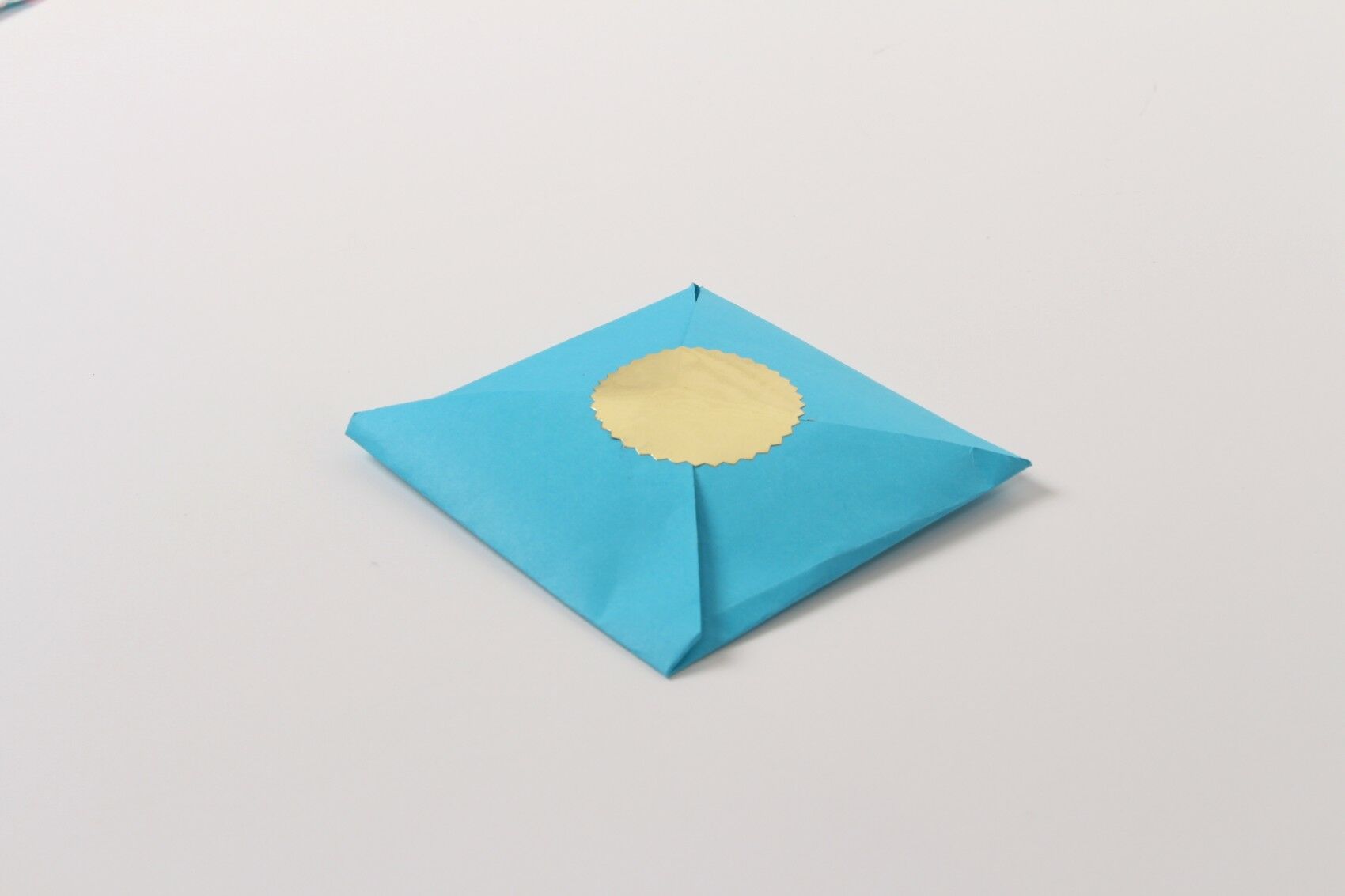 Final product, cookie folded in blue envelope with gold seal holding it together