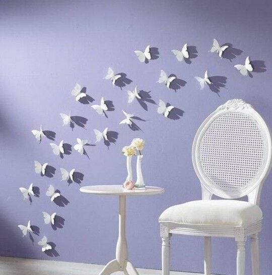 white butterflies, white chair, and white table against lavender purple wall