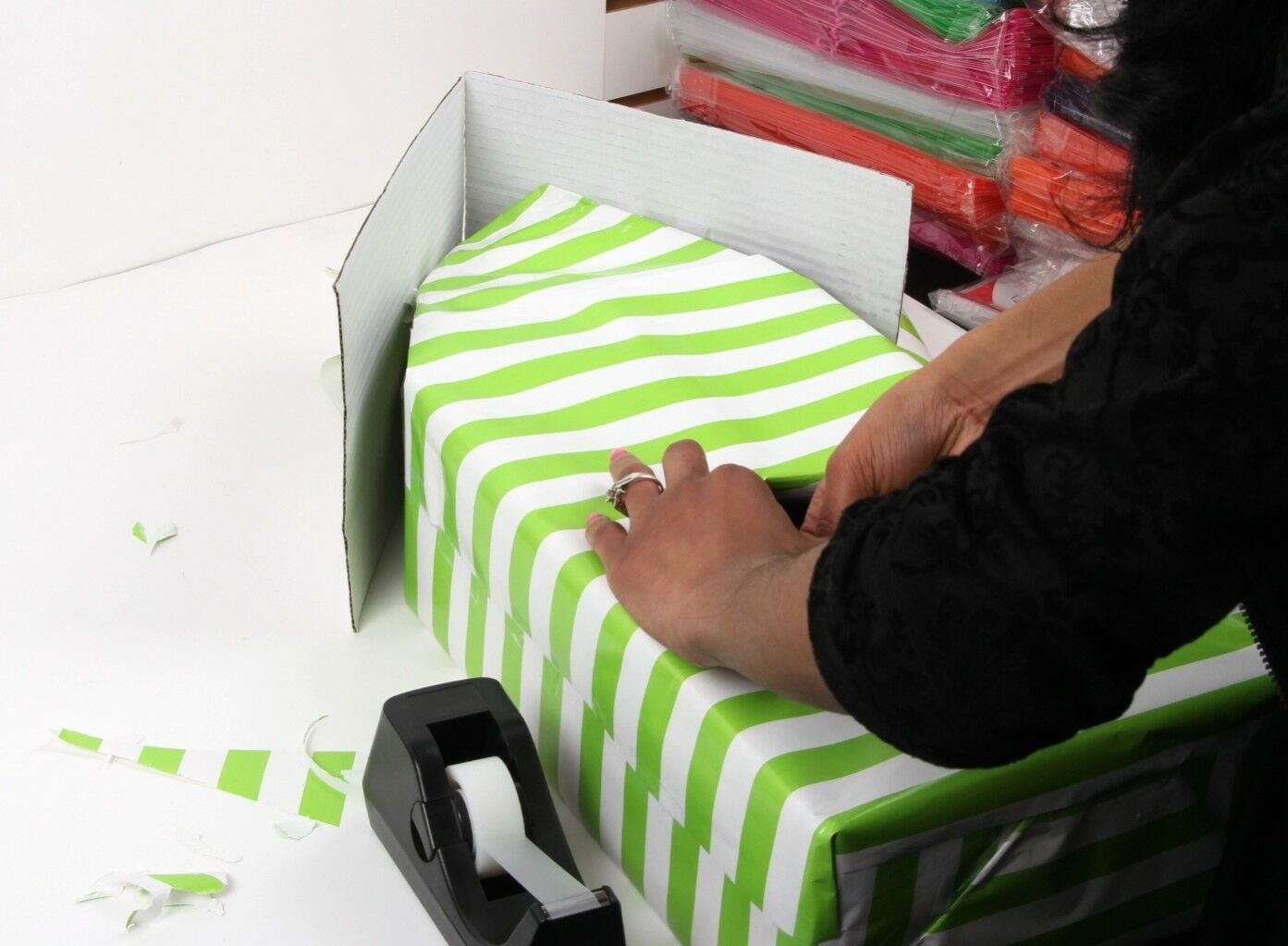 woman covering shoebox in wrapping paper