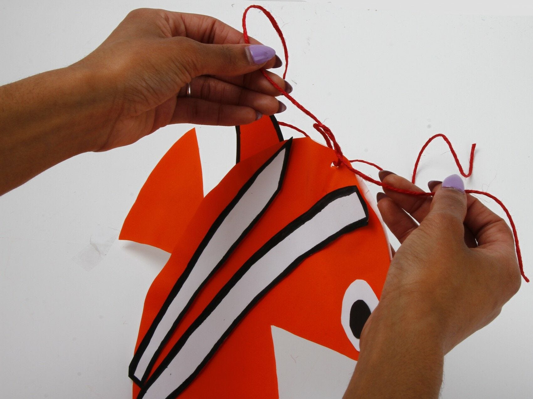 tying string in hole in fish tying twine in clownfish hole