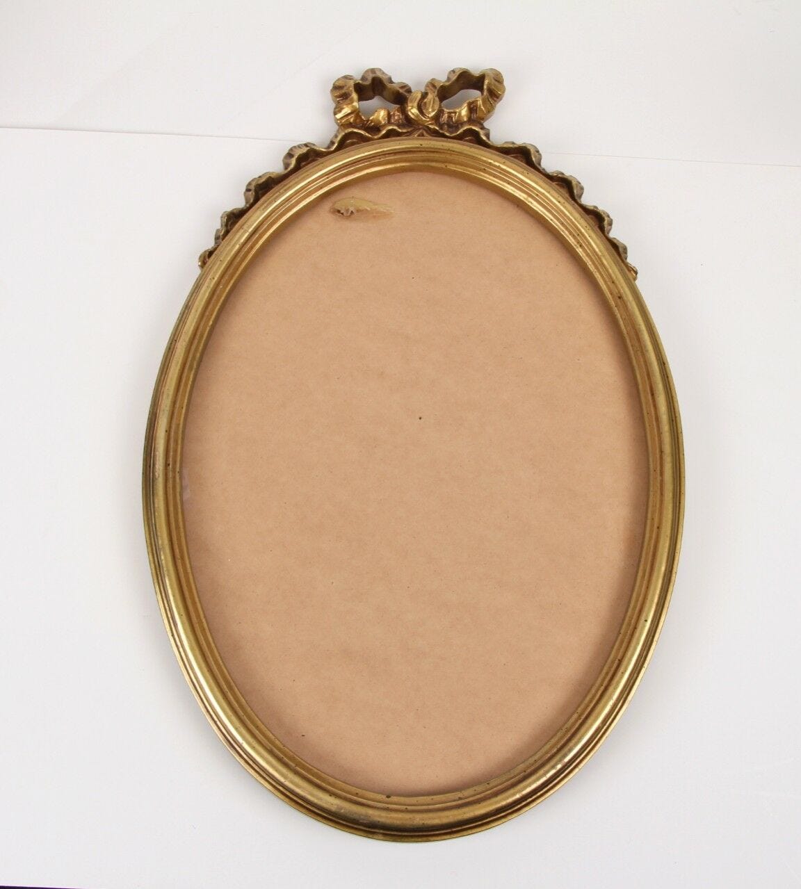 gold mirror frame with ribbon design on top no glass