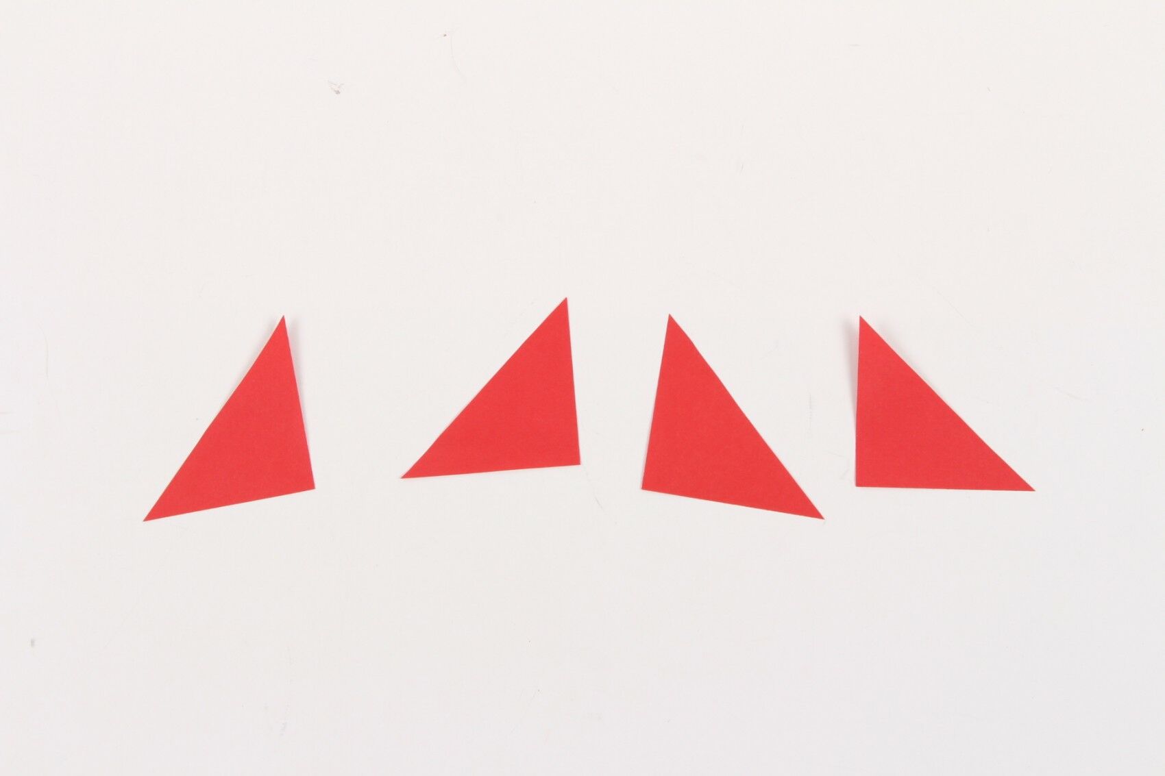 red paper triangle cutouts on white background