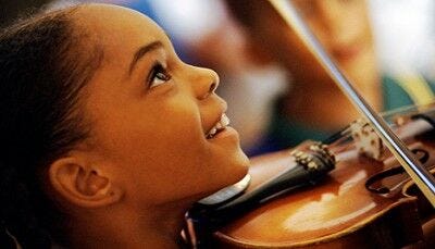 portrait of young girl smiling and playing violin