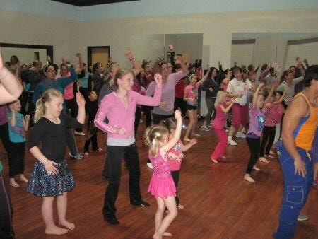 zumba class filled with moms and little girls dancing and keeping in shape