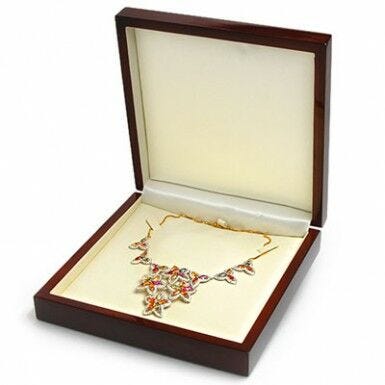 jeweled necklace displayed in open wooden jewelry box