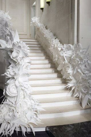 white papercut wedding flowers lining staircase rails