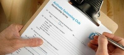 hands holding pen and membership survey