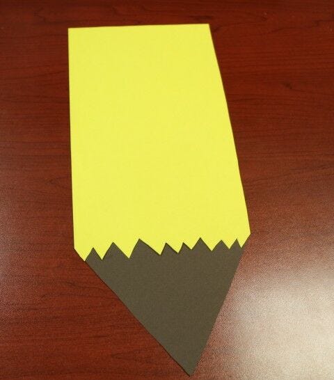 yellow paper pencil body glued onto brown paper wood