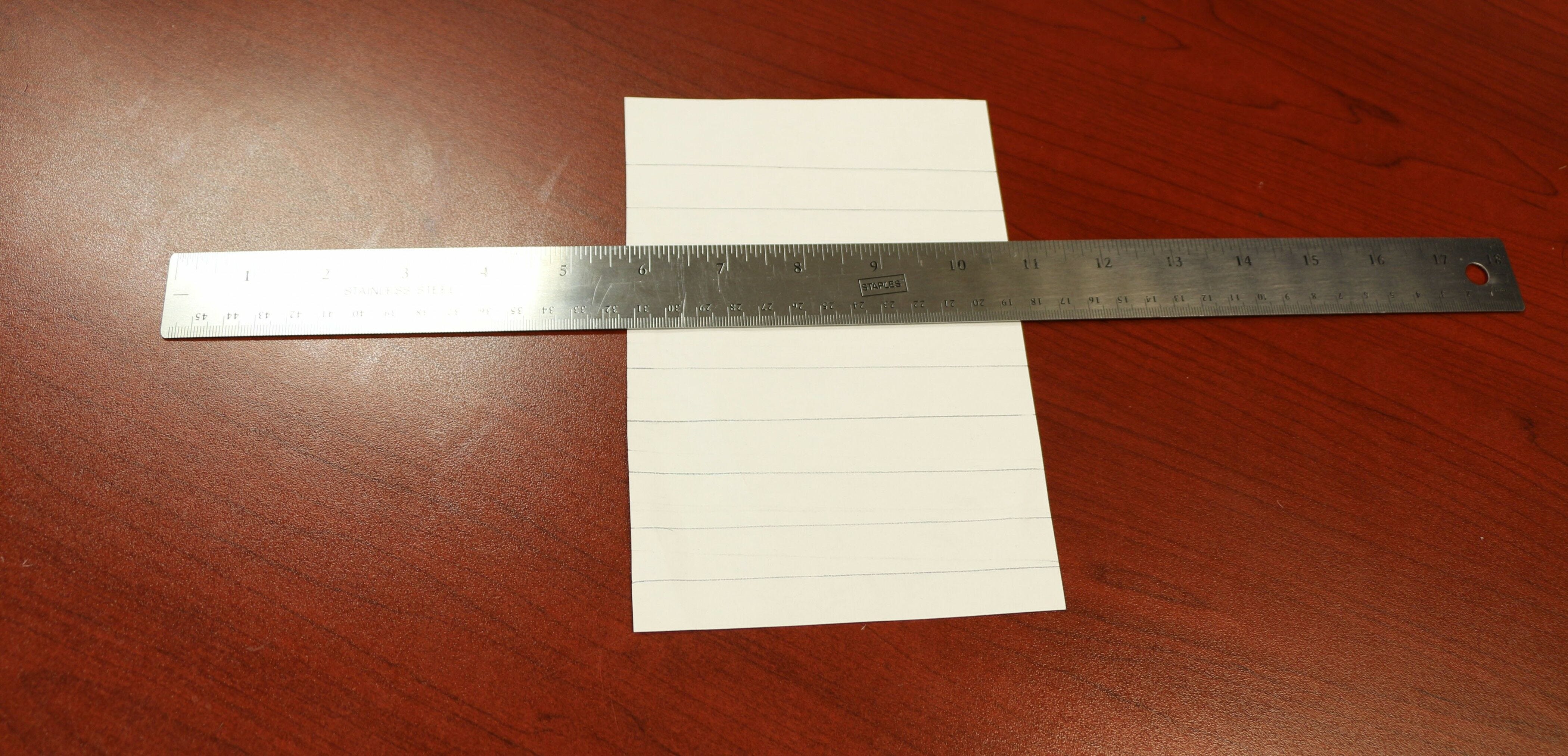 silver metallic ruler on sheet of white lined paper