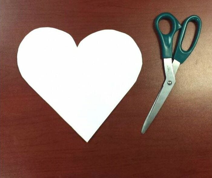 white labor day paper craft heart cutout with pair of scissors on desk