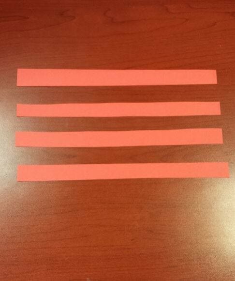 4 red paper stripes strips laid out on desk