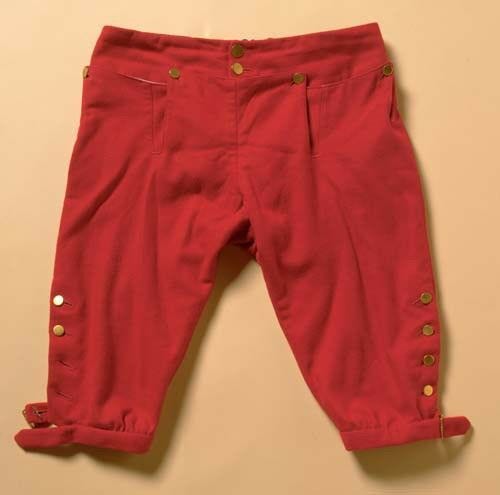 red breeches with gold buttons on beige background