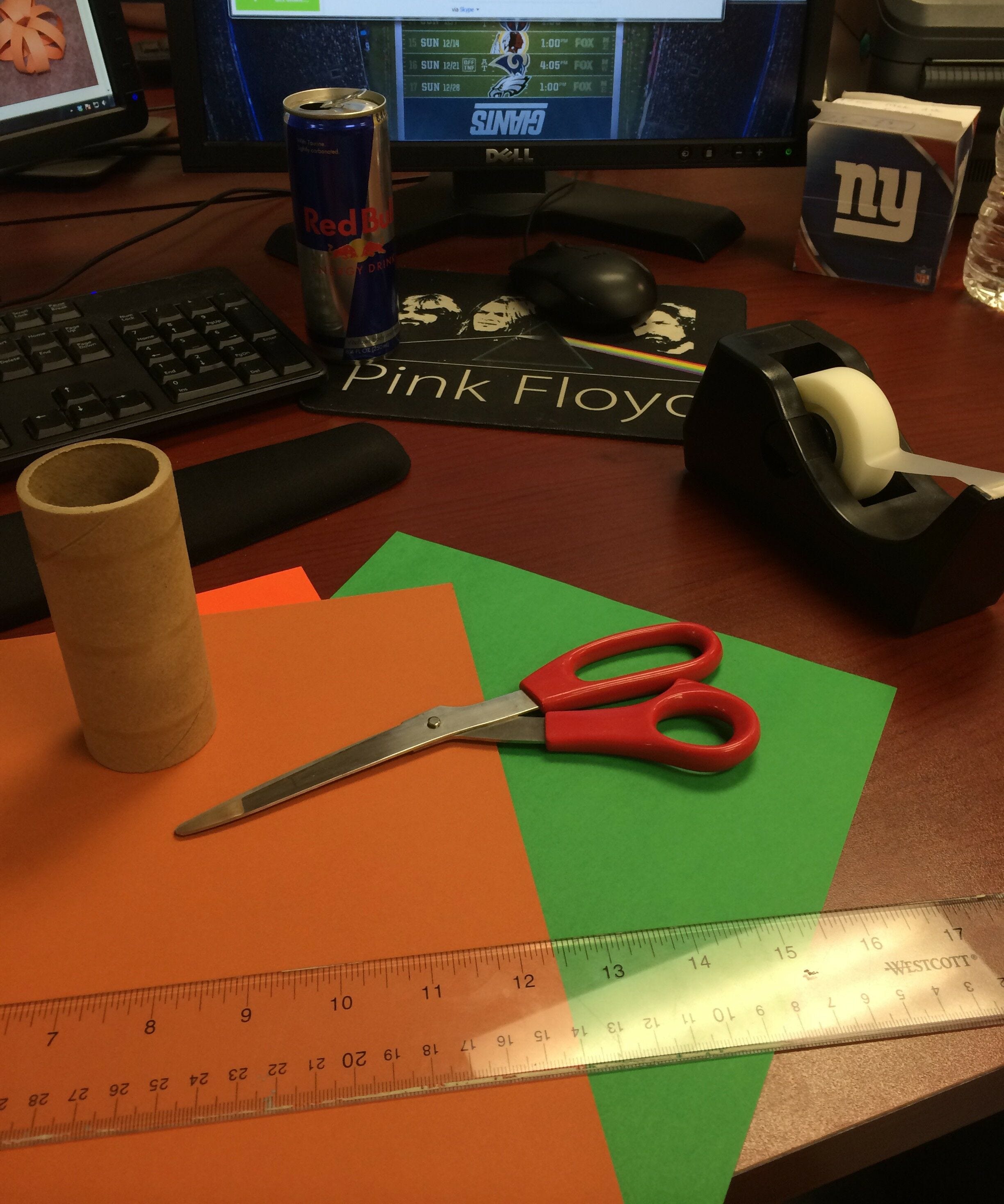 scissors, ruler, tape dispenser, construction paper on desk