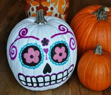 pumpkin carving alternatives: white painted pumpkin with colorful face and design