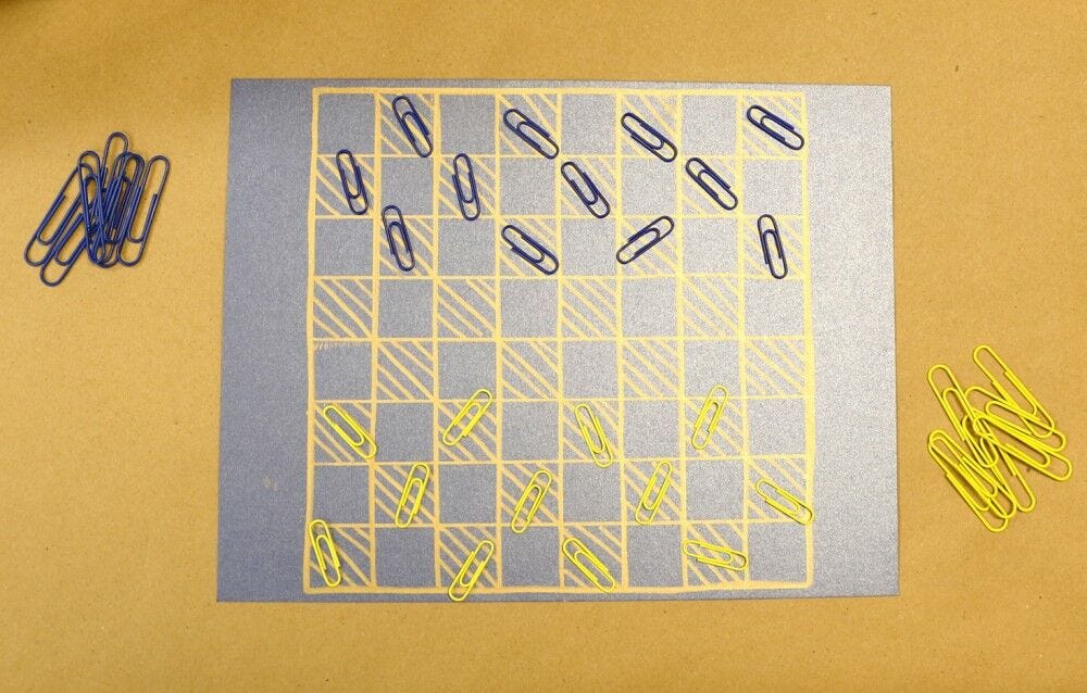 Blue and yellow paper clips as checkers