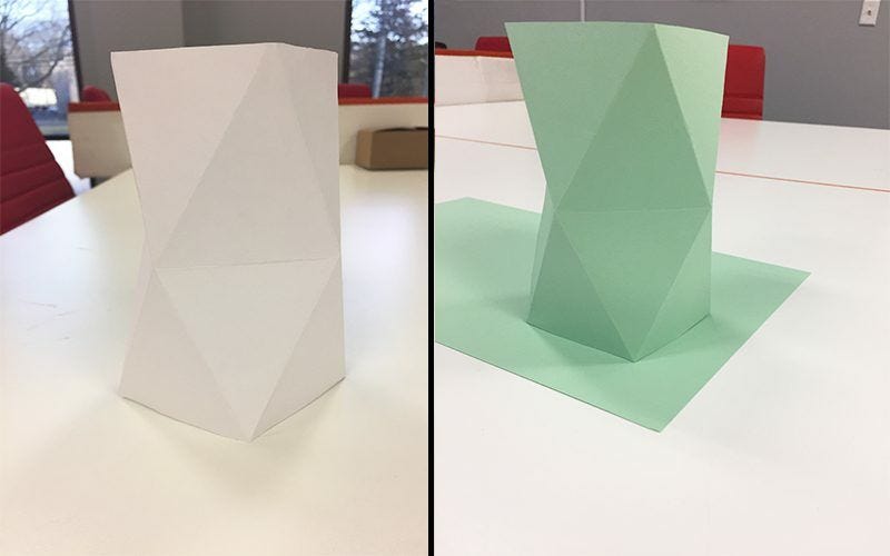 green and white geometric paper vases standing on white desks