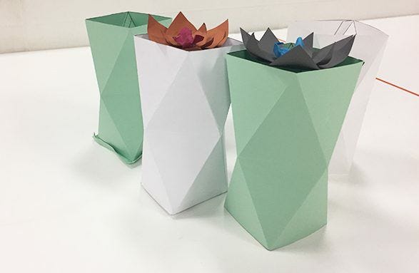 green and white geometric paper vases holding paper succulents 