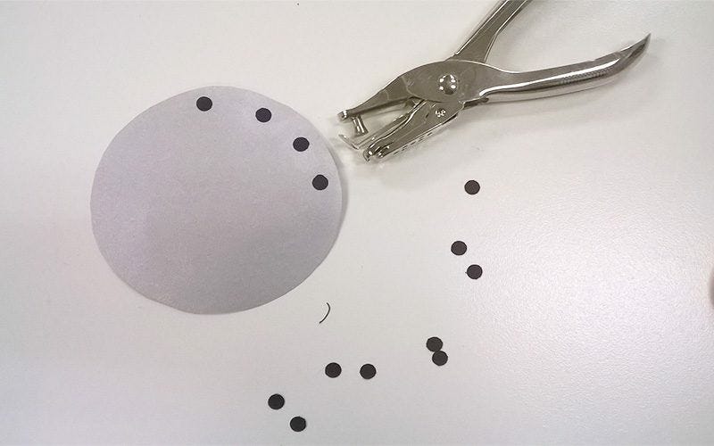 Small black dots punched from black paper glued to smaller white circle