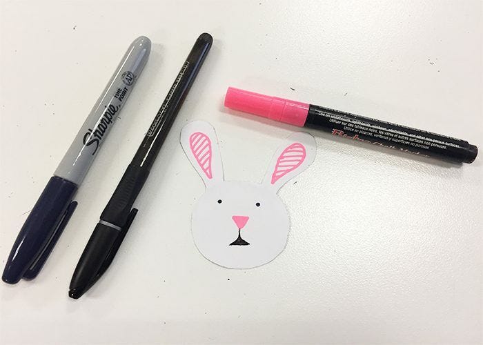 Easy DIY Easter Sticker Egg Decorations, Bunny face drawn on cutout with black and pink pens and a black marker