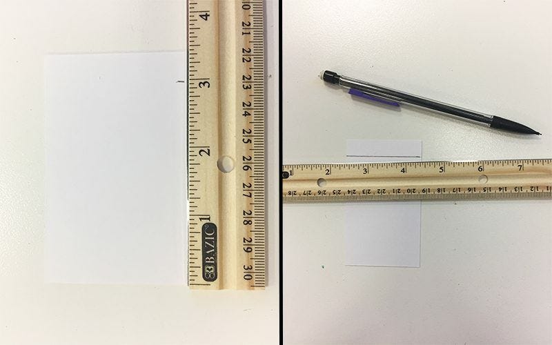 using a wooden ruler to draw a line on white paper