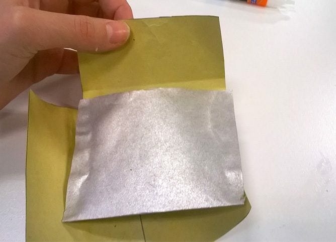 hands folding silver foil paper