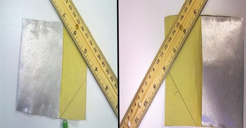 measuring silver foil paper with wooden ruler and drawing pencil lines