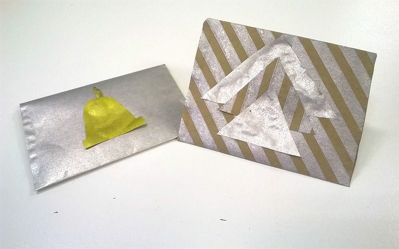 silver metallic envelope with golden bell design and silver striped triangle envelope