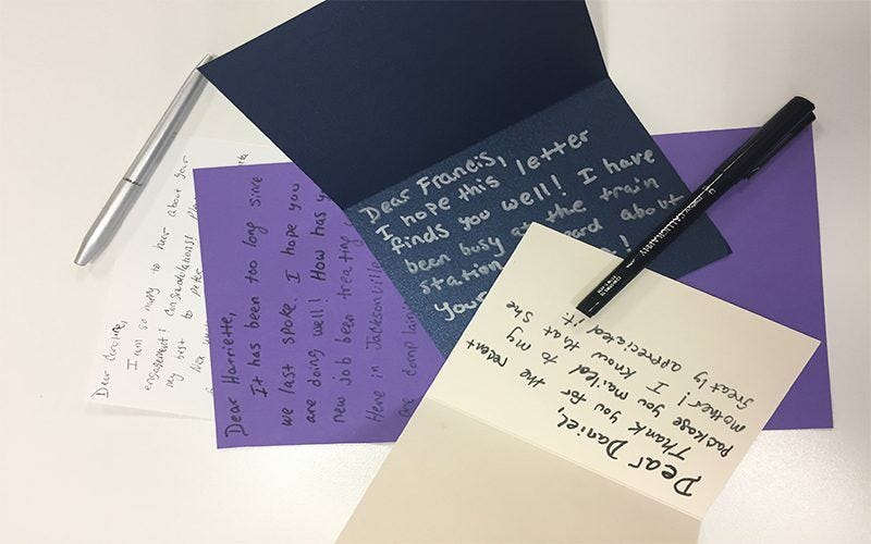 Hand-written letters on assorted colored note cards along with pens