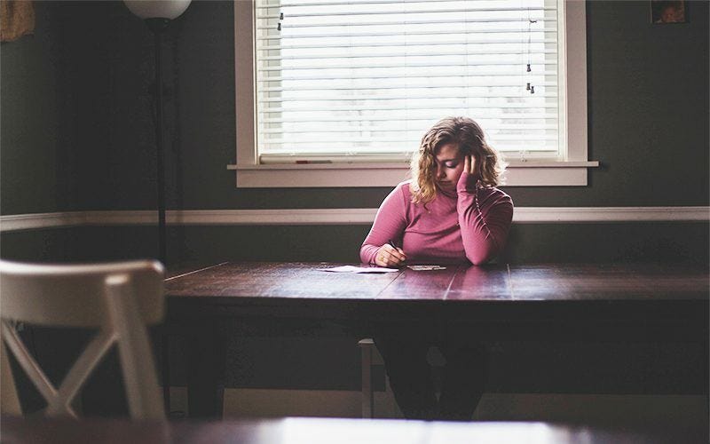 Woman in her dining room writing a letter