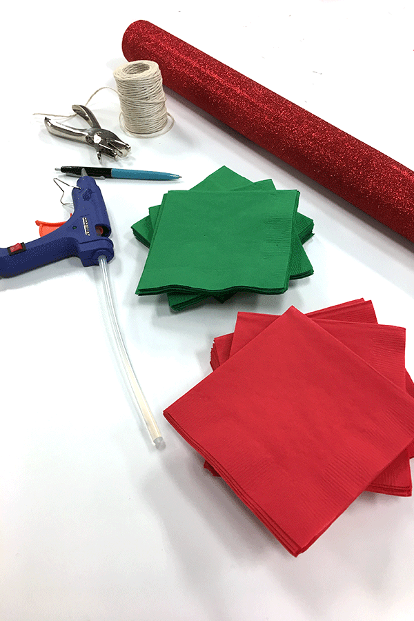 red and green napkins, hot glue gun, hole puncher, twine, red glitter wrapping paper