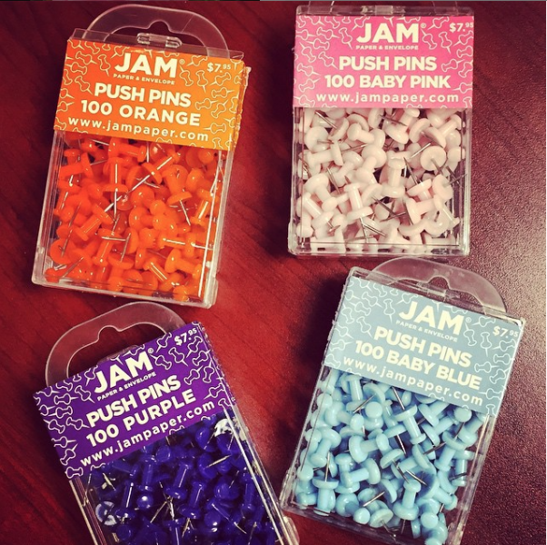 boxes of jam colorful push pins in orange baby pink purple and baby blue