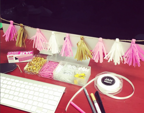 Decorated workspace, multicolored ribbon strung around desktop, colorful paperclips