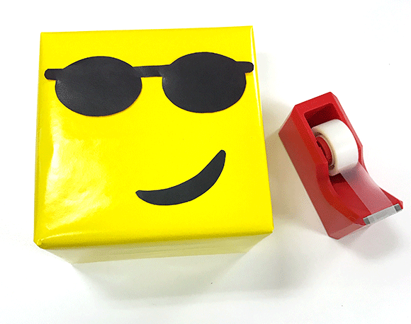 present wrapped in emoji gift wrap, tape
