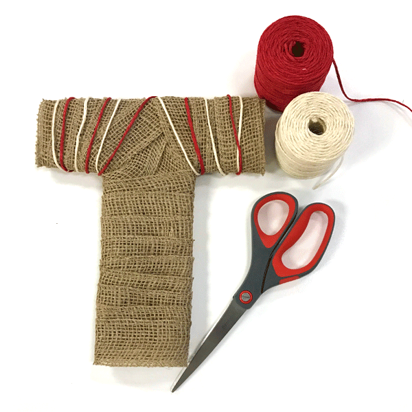 red and white twine wrapped in alternating stripes around diy burlap letters with scissors