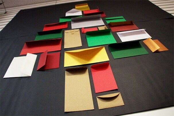 assortment of different-sized colorful envelopes in shape of christmas tree advent calendar idea