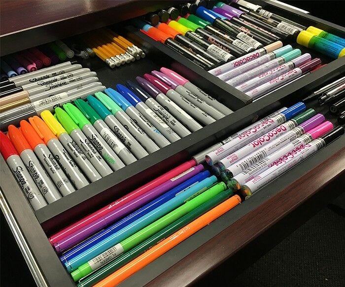 colored markers pens and pencils color-coordinated in drawer