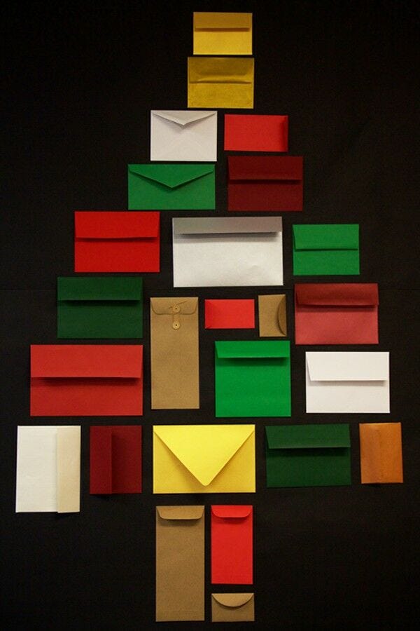 multi colored envelopes of different sizes arranged in christmas tree shape as advent calendar idea