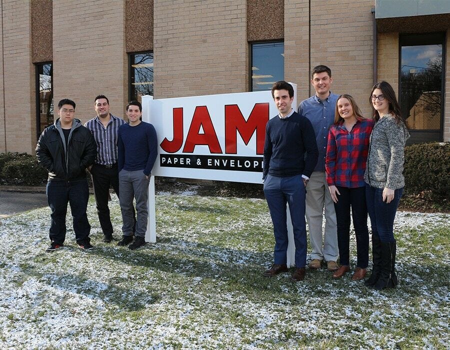 Employees with JAM sign outside office