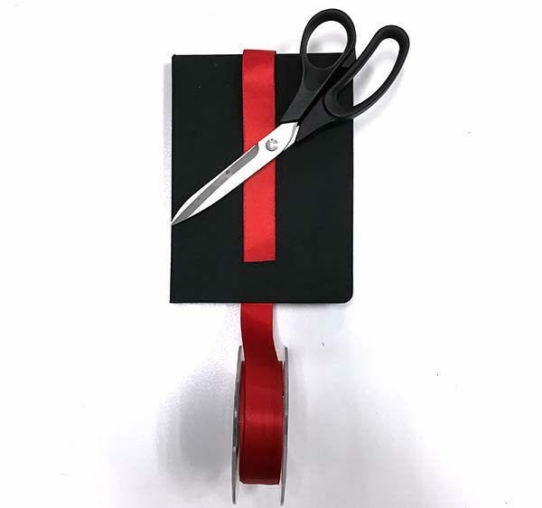 Red ribbon over black measuring block, scissors